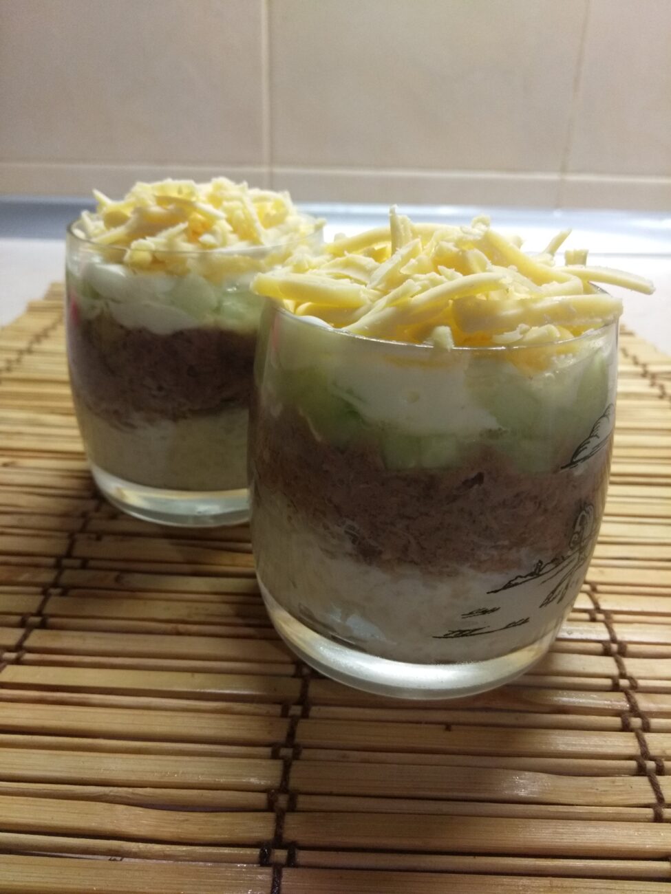 Слоёный салат из тунца, риса, огурцов и сыра