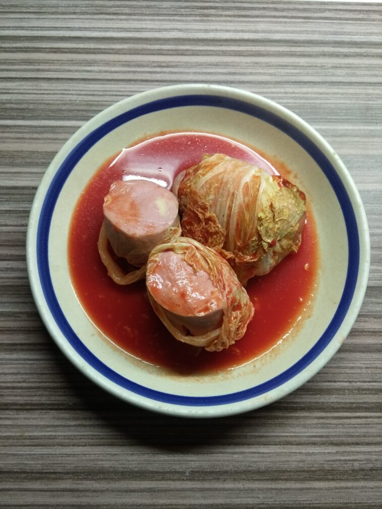 Сардельки, запеченные в капустных листьях